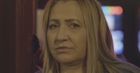 a woman in a blue shirt is staring at the camera